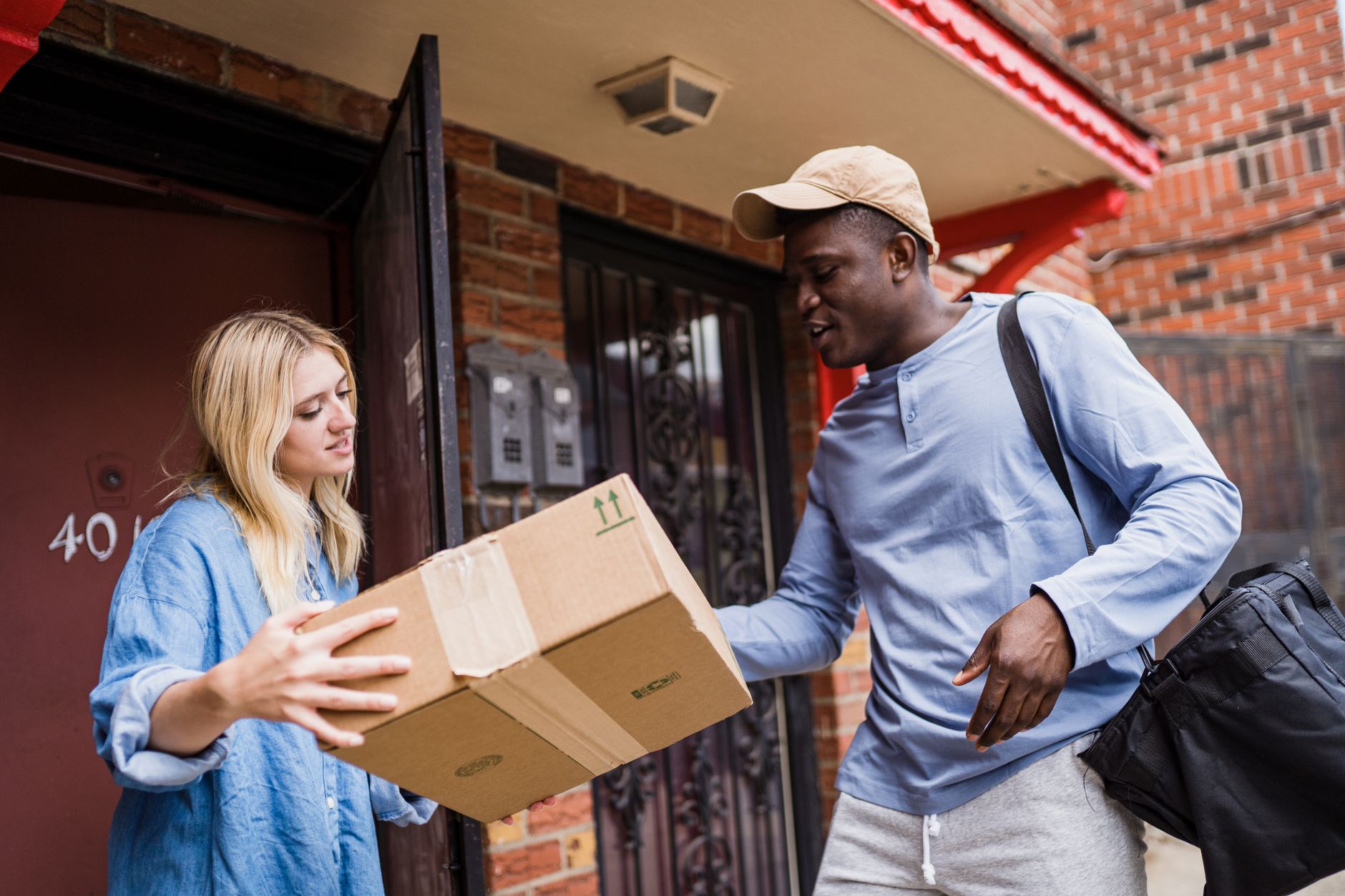 A courier handing delivered documents to a customer at their door
